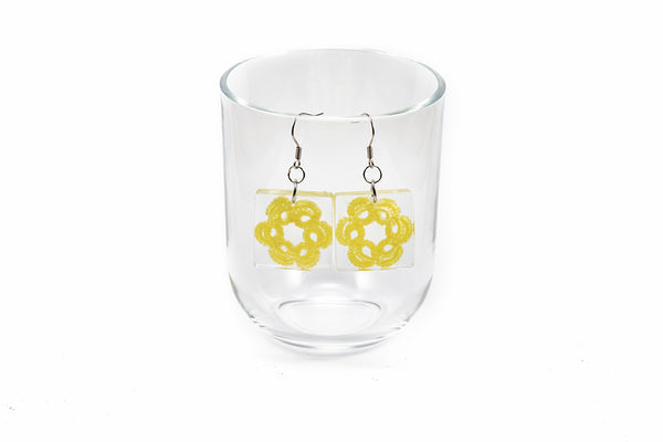 Viseči uhani kvadratne oblike iz epoksidne smole, s čipko v obliki cveta. Na kaveljčkih iz nerjavečega jekla.