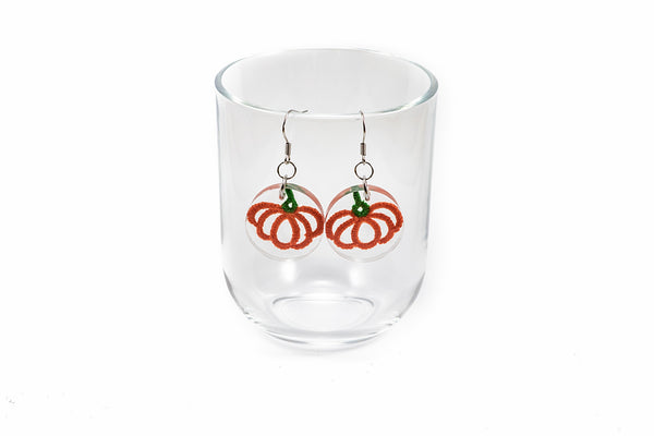 Okrogli viseči uhani s čipko v obliki oranžne buče. Visijo na kaveljčkih iz nerjavečega jekla.