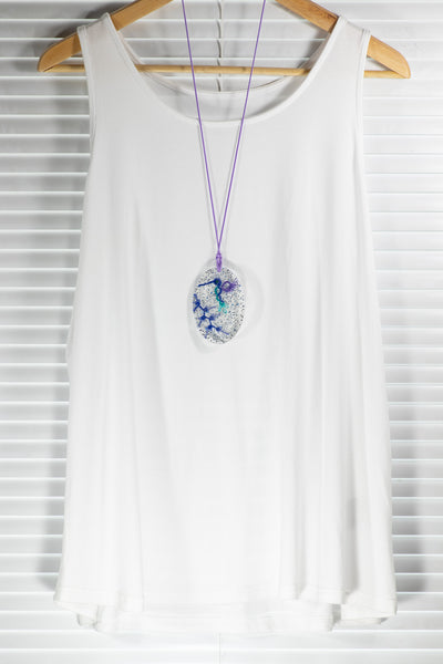 OVAL PENDANT OF A HUMMINGBIRD IN THE SNOW