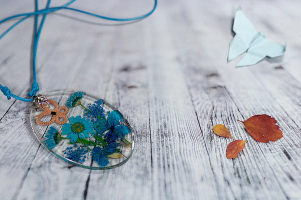 OVAL TURQUOISE PENDANT WITH AN APRICOT BUTTERFLY ON BLUE FLOWERS