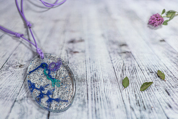 OVAL PENDANT OF A HUMMINGBIRD IN THE SNOW