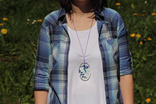 OVAL PENDANT OF A HUMMINGBIRD IN THE SNOW