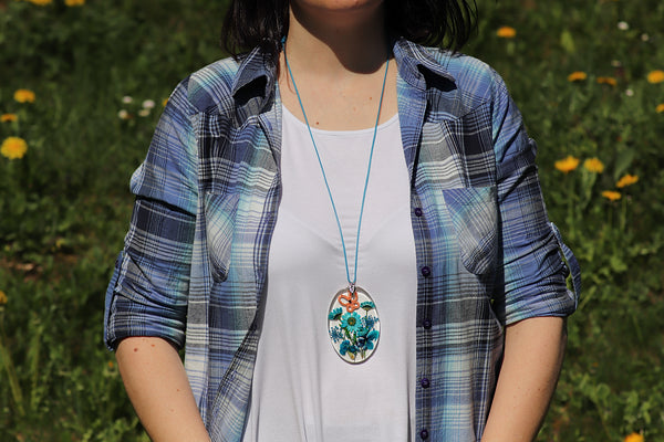 OVAL TURQUOISE PENDANT WITH AN APRICOT BUTTERFLY ON BLUE FLOWERS