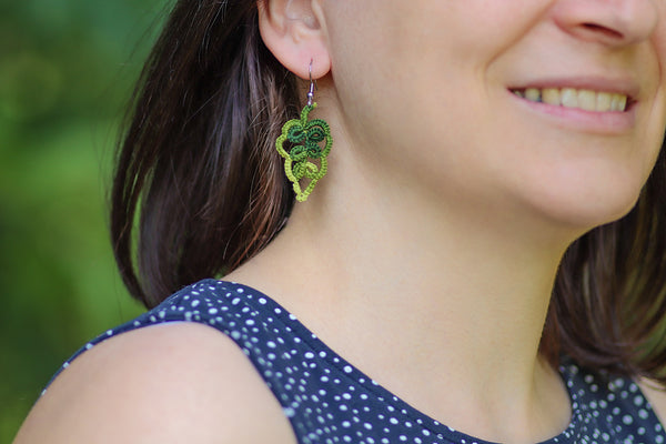 Čipkasti viseči uhani v obliki hrastovega lista na izbiro v različnih prelivajočih odtenkih zelene in oranžne, ki visijo na kaveljčkih iz nerjavečega jekla.