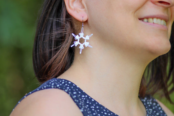 Viseči uhani snežinka iz bele čipke na kaveljčkih iz nerjavečega jekla.