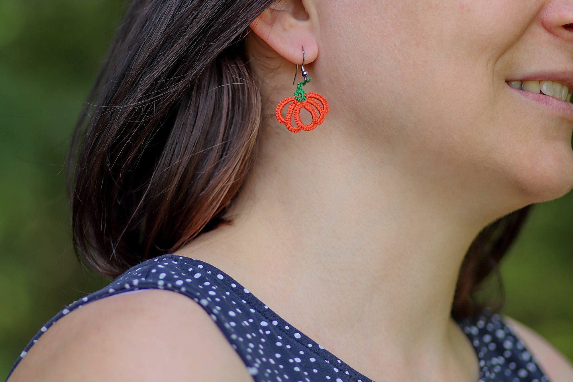 Čipkasti viseči uhani v obliki oranžne bučke, ki visijo na kaveljčkih iz nerjavečega jekla.